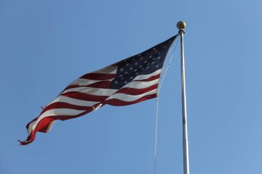 Mavi gökyüzü arka planında ABD Bayrağı dalgalanıyor