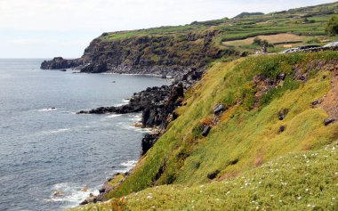Uçurumdan okyanus manzarası, aşağıdaki volkanik kayalar, Cinco Ribeiras, Terceira, Azores, Portekiz - 28 Temmuz 2022