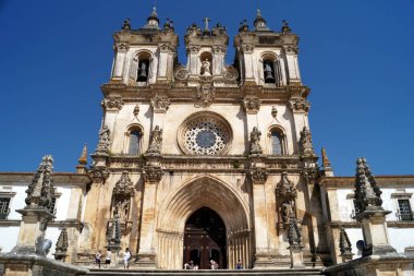 Alcobaca Monastery, portal and rose window of the church are original early 13th century Gothic, while the towers are 18th century Baroque, Alcobaca, Portugal - August 8, 2016