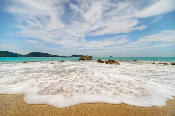 Kumsalda beyaz köpüklü deniz dalgası manzarası Patong sahilinde mavi gökyüzü Phuket Tayland