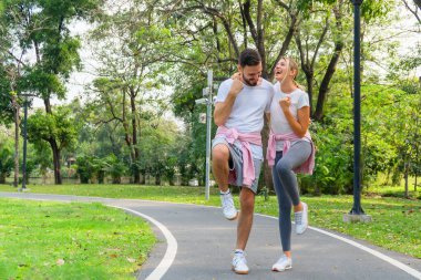 Spor giyimli beyaz bir çift parkta egzersiz yapmak için birlikte koşuyor. Atletik insanların sağlıklı ve sağlıklı yaşam tarzları