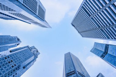 Merkez iş bölgesindeki gökdelenlerin ve gökdelenlerin altında mavi gökyüzü arka planına sahip