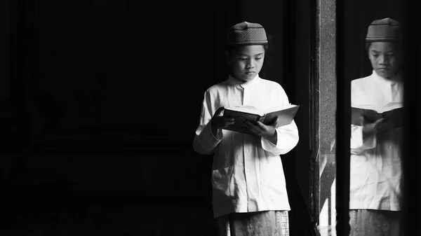亚细亚穆斯林学生站在伊斯兰清真寺里 Alquran 以了解安拉的神课 并在墙上用黑白进行反思 — 图库照片