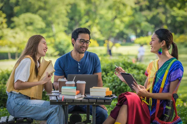 group of diverse asian university LGBTQ student classmate, transgender person, woman and gay as teamwork doing group homework together in campus park