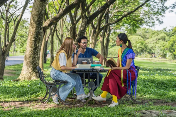 group of diverse asian university LGBTQ student classmate, transgender person, woman and gay as teamwork doing group homework together in campus park