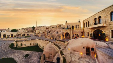 Gün batımında Goreme kasabası Kapadokya Türkiye 'deki Cappadocia Cape Otel' in panoramik manzara manzarası