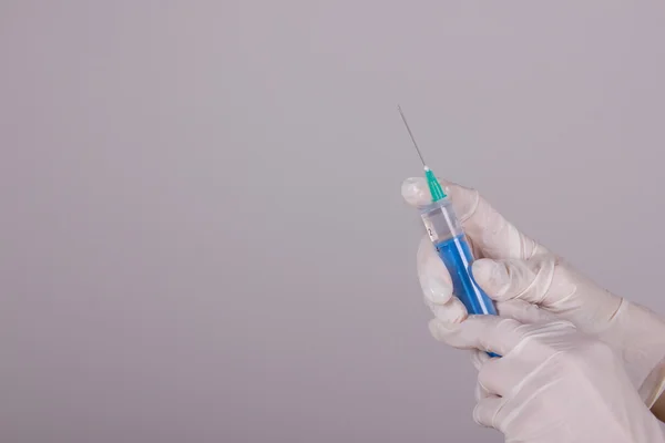 Medical gloves and syringe with needle — Stock Photo, Image