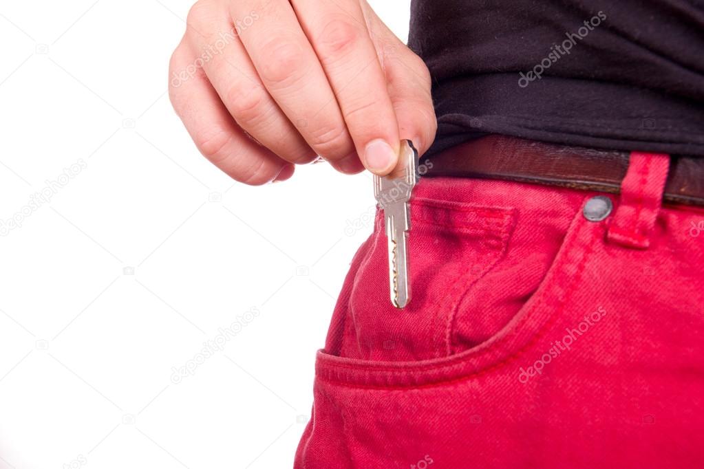 Hand puts the key in red jeans pocket