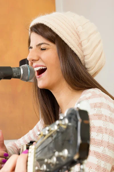 Dziewczyna głośno śpiewa i gra na gitarze — Zdjęcie stockowe