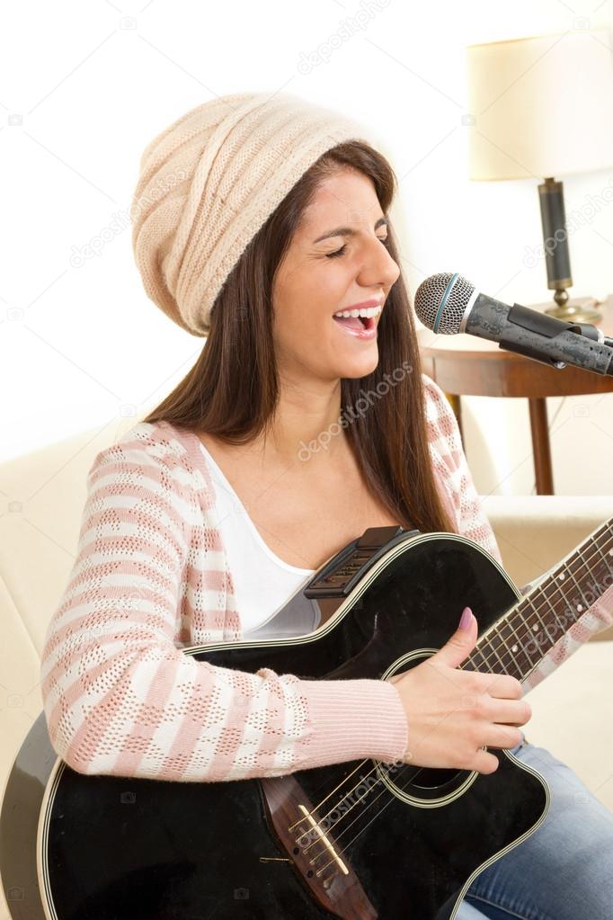 girl with a guitar singing on microphone