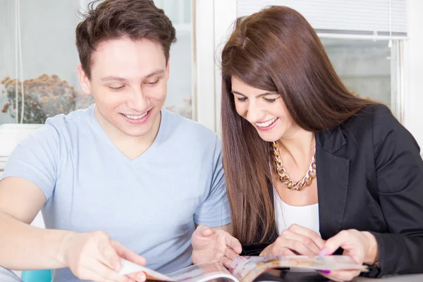 Couple reading magazine and laughing — Stock Photo, Image