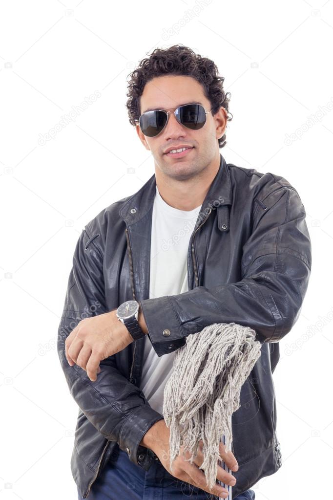 man in a leather jacket leaning on a broom