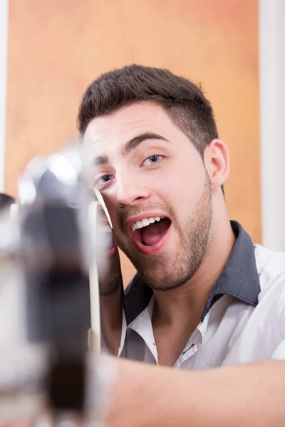 Jovem sorridente homem com expressão apontando guitarra para você — Fotografia de Stock