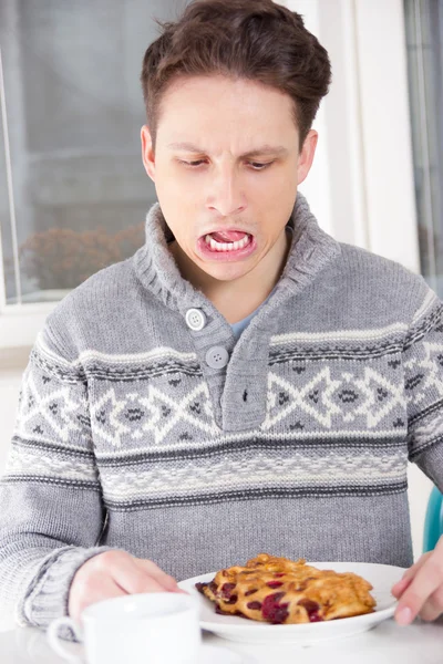 Hombre disgusta postre que está sobre la mesa — Foto de Stock