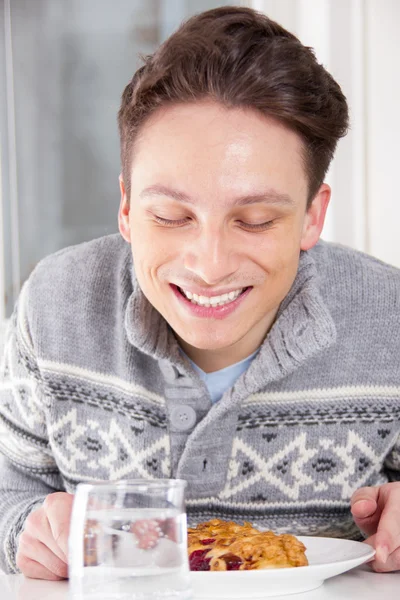 Homme sentant le dessert sur la table — Photo