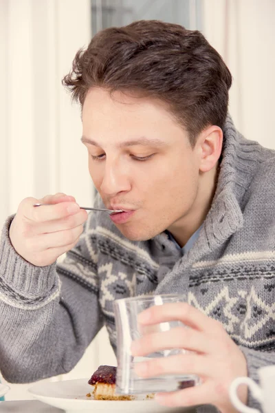 Junger Mann isst ein Dessert — Stockfoto