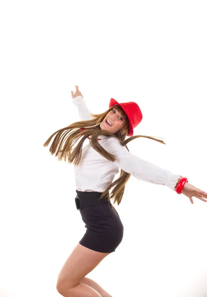 Ganska leende flicka med röd hatt hoppning — Stockfoto