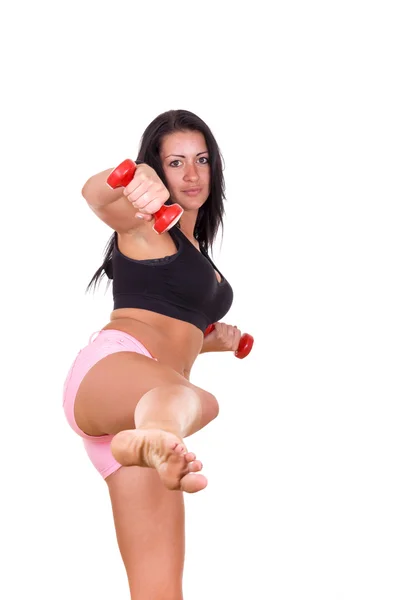 Atraente mulher dando um pontapé com perna levantando halteres — Fotografia de Stock