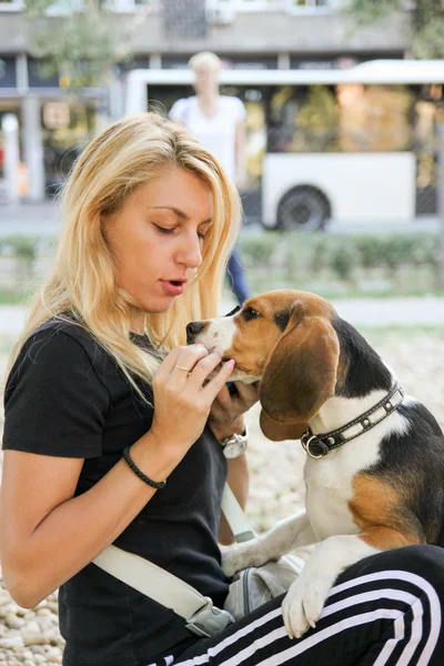 Красивая женщина держит и кормит щенка — стоковое фото