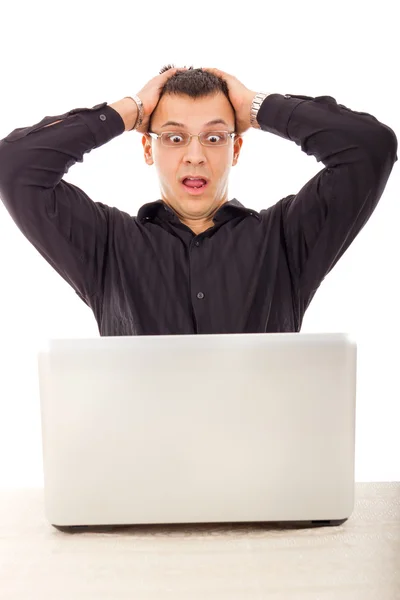 Man in black shirt looking at laptop with wide eyes open — Stock Photo, Image