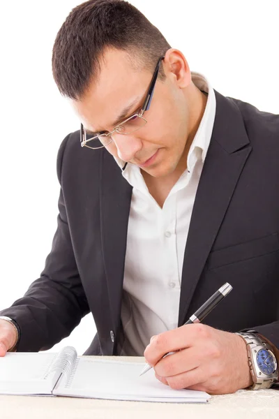 Serious man in suit with glasses writing in notebook — Stock Photo, Image