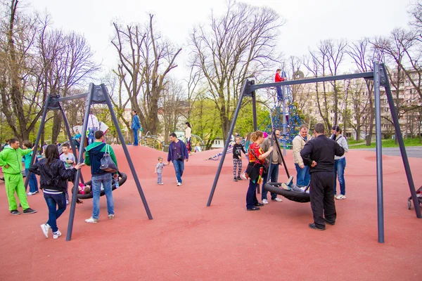 Parque infantil en un parque lleno de niños — Foto de Stock