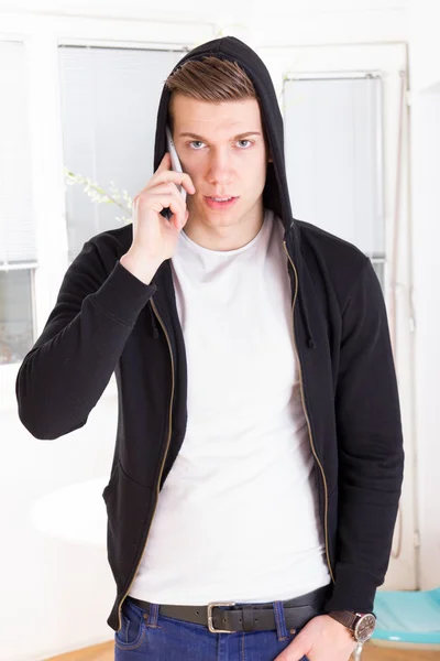 Casual focused man with hooded on the phone — Stock Photo, Image