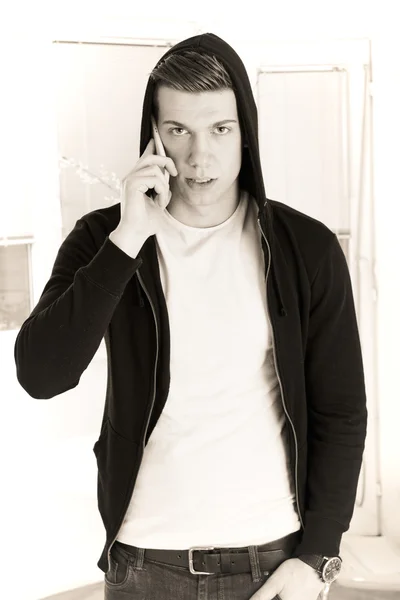 Hombre guapo con capucha en el teléfono —  Fotos de Stock