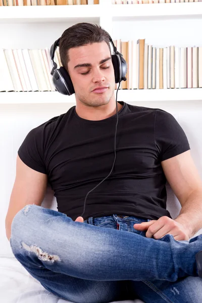 Hombre relajante en sofá con auriculares — Foto de Stock