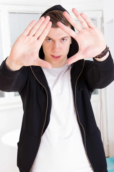 Hombre urbano de moda con capucha enmarcando su cara con las manos — Foto de Stock