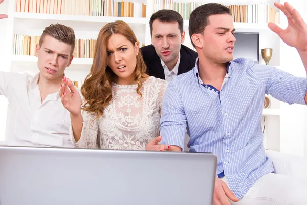 Gefrustreerd toevallige groep vrienden zittend op de bank kijken naar l — Stockfoto