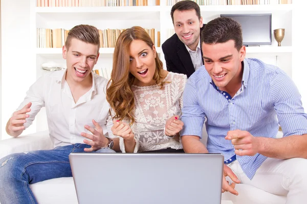 Grupo de amigos assistindo e trabalhando juntos no laptop — Fotografia de Stock