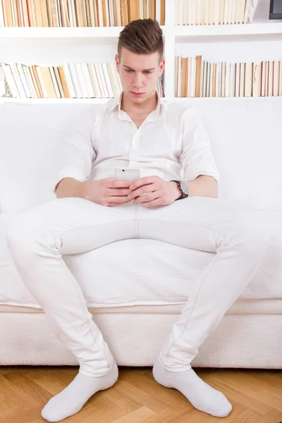 Solitario giovane uomo in bianco sms messaggio sul cellulare — Foto Stock