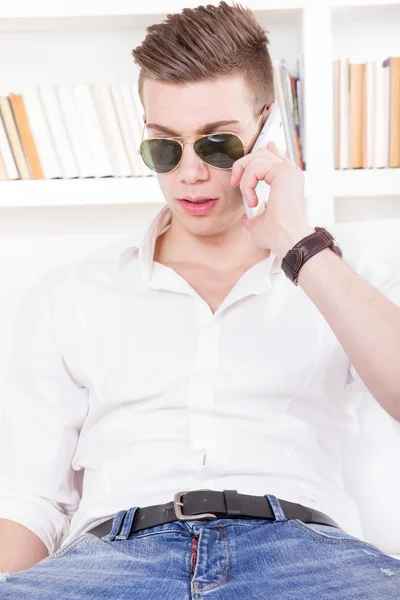 Современный парень с солнцезащитными очками, говорящий по телефону — стоковое фото