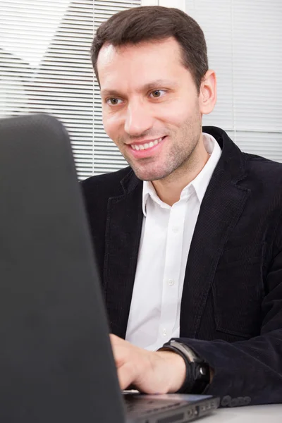 Goodlooking  smiling business man sitting at table at home or of — Stock Photo, Image