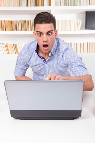 Mann schaut überrascht auf Inhalt auf Computerbildschirm — Stockfoto