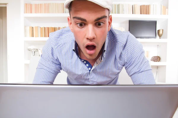 Retrato de un estudiante sorprendido mirando al monitor de su regazo —  Fotos de Stock