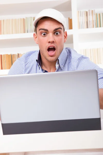 Homem de negócios chocado usando boné olhando para seu monitor gritando — Fotografia de Stock