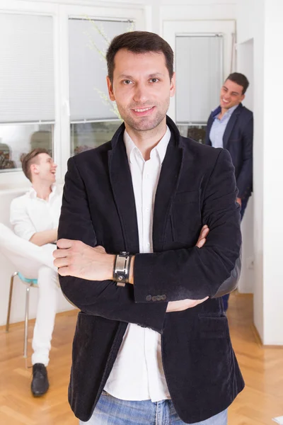 Successful handsome man standing with his friends colleagues in — Stock Photo, Image