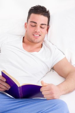 muhteşem adam yatakta gülümseyen içinde kitap okumak