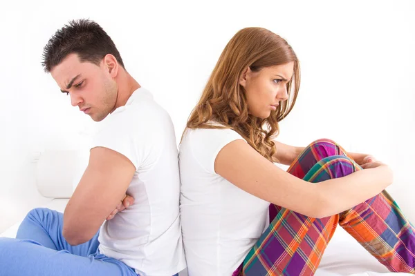 Couple ignoring each other sitting back to back on bed during a — Stock Photo, Image