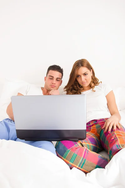 Paar vergadering naast elkaar in bed ontspannen met computer — Stockfoto