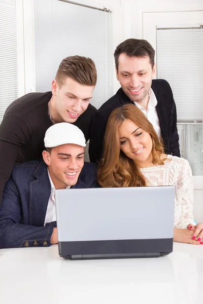 Group of friends and colleagues looking at laptop together — Stock Photo, Image