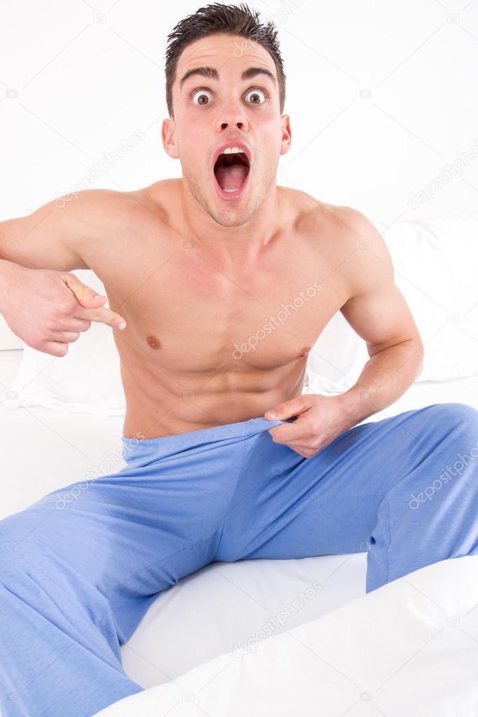 upset man on bed in pajamas having problems with impotence