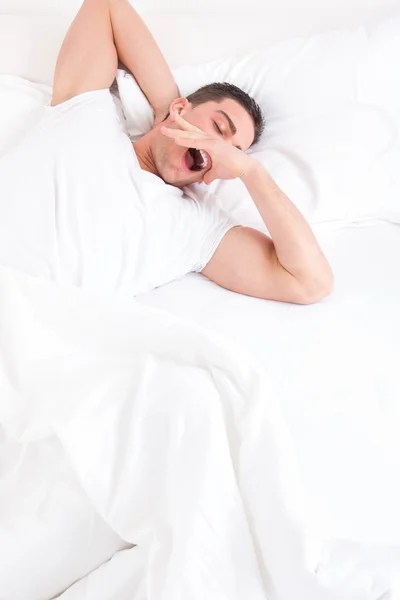 Casual uomo svegliarsi in camera da letto e si estende con sbadiglio i — Foto Stock