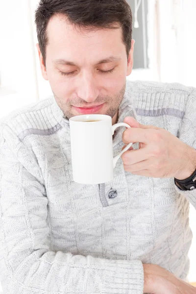 Morgens Porträt eines gutaussehenden Kerls, der Kaffeebecher riecht und hält — Stockfoto