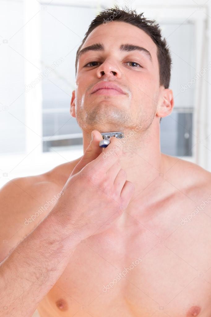 sexy man shaving his beard with razor
