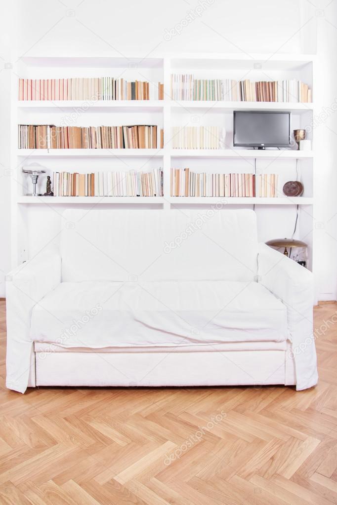 Home library with sofa or couch in white living room