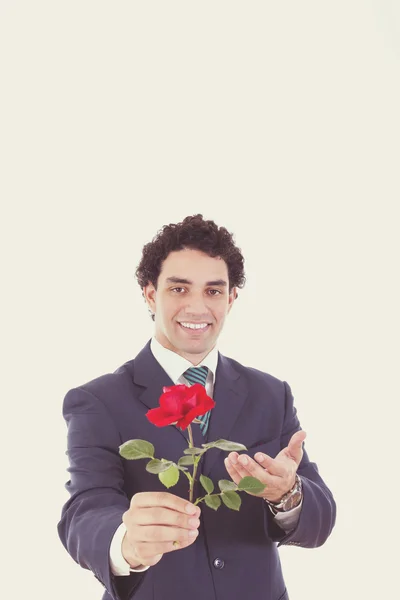 Hombre en un traje dando una rosa con la mano a la cámara — Foto de Stock