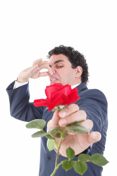 Homme en costume lance une rose et le donne à l'appareil photo avec le visage — Photo